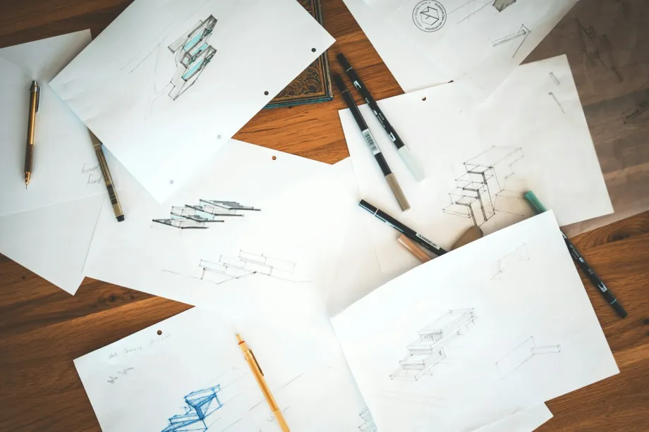 Printed website wireframe sheets laid out on a brown wooden surface